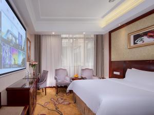 a hotel room with a large bed and a large screen at Vienna Hotel Guangzhou Panyu NanCun in Guangzhou