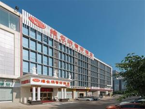 龙岗维也纳酒店深圳宝能城市广场店的一座顶部有标志的大楼