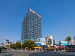 un grand bâtiment avec un panneau en haut dans l'établissement Vienna International Hotel Taicang Nanyang Plaza, à Taicang