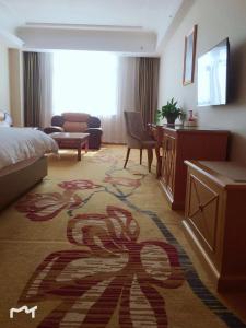 a hotel room with a bed and a living room at Vienna Hotel Huiyang Sanhe Square in Huizhou