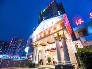 Vienna Hotel Shenzhen Fuyong Qiaotou في باوان: مبنى فيه اعمدة في المدينة ليلا
