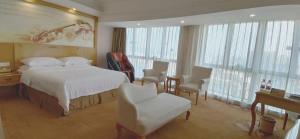 Habitación de hotel con cama, mesa y sillas en Vienna Hotel Dongguan Shatian Humen Port, en Dongguan