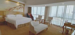 a hotel room with a bed and a table and chairs at Vienna Hotel Dongguan Shatian Humen Port in Dongguan
