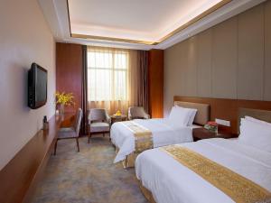 a hotel room with two beds and a television at Vienna Hotel Dongguan Tangxia Guanlan Lake Golf Club in Dongguan