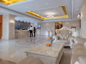 een grote lobby met een tafel en stoelen en een bar bij Vienna Hotel(Zhangzhou Jiaomei WanYi square store) in Longhai