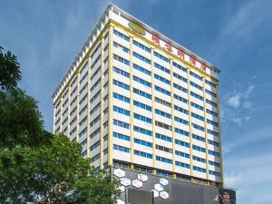 ein hohes Gebäude mit einem Schild darüber in der Unterkunft Vienna Hotel Shenzhen Fenghuang Road in Shenzhen