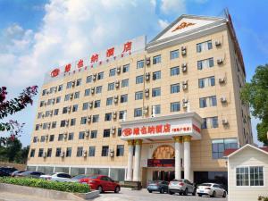 a hotel building with cars parked in front of it at Vienna Hotel Anhui Mingzhu Square in Ershilipu