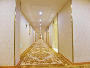 um corredor de um edifício com piso em azulejo em Vienna International Hotel Meizhou Dingzi Bridge em Meizhou