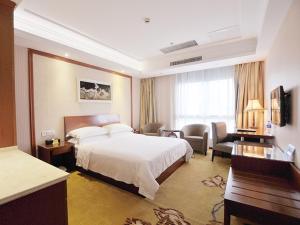 a hotel room with a bed and a desk at Vienna Hotel Nantong Tongzhou Bus Station in Tongzhou