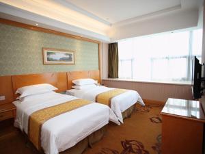 a hotel room with two beds and a window at Vienna Hotel Jiangsu Kunshan Exhibition Center in Kunshan