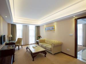 ein Wohnzimmer mit einem Sofa und einem Tisch in der Unterkunft Vienna Hotel Heyuan High-Tech Yi Road in Heyuan