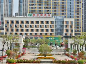 a building in a city with a park with flowers at Vienna Hotel(Zhangzhou Jiaomei WanYi square store) in Longhai +4 photos
