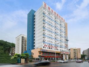 Un grand bâtiment avec un panneau en haut dans l'établissement Vienna International Hotel Shenzhen Caopu Jindaotian, à Shenzhen