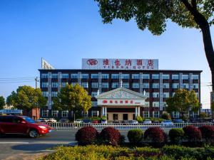 un grand bâtiment avec un panneau en haut dans l'établissement Vienna Hotel Hangzhou Xiaoshan Airport, à K'an-shan-chen