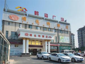 een gebouw waar auto's voor geparkeerd staan bij Vienna Classic Hotel Shanghai Hoingqiao National Exhibition Centre Xujing in Shanghai