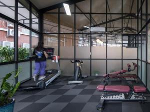 a woman walking on a treadmill in a gym at Vienna Hotel Guangzhou South Panyu Bridge in Guangzhou