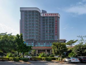 un grande edificio con auto parcheggiate in un parcheggio di Vinenna International Hotel Shenzhen shajing a Bao'an