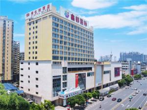 a tall building with a sign on top of it at Vienna Hotel Hunan Hengyang Railway Station in Hengyang