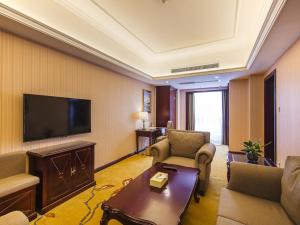 una sala de estar con TV de pantalla plana en una habitación de hotel en Vienna Hotel Xi'an International Exihibition Center en Xi'an