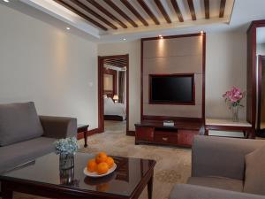 a living room with a couch and a television at Vienna Hotel Kunming North Caiyun Road Asia in Kunming