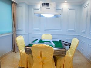 un comedor con una mesa con sillas amarillas en Vienna Hotel Dongguan ChangAn Wanda Plaza, en Dongguan