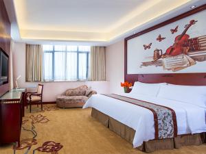 Habitación de hotel con cama grande y escritorio. en Vienna Hotel Dongguan Wanjiang Road, en Dongguan