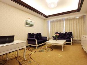 a living room with two couches and a piano at Vienna International Hotel Yangzhou Libao Square in Yangzhou