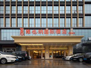 Vienna International Hotel Changsha Ziwei Road في تشانغشا: مبنى كبير فيه سيارات تقف امامه