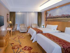 een hotelkamer met 2 bedden en een televisie bij Vienna Hotel Dongguan Chengcaiyuan International Plaza in Dongguan