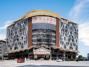 a large building with cars parked in front of it at Vienna Hotel Guangzhou Baiyun Airport in Guangzhou +11 photos
