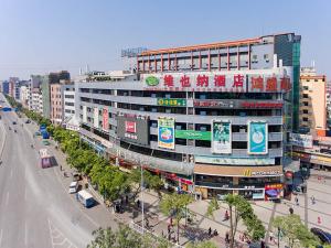 un grand bâtiment avec des panneaux sur le côté d'une rue dans l'établissement Vienna Hotel Guangzhou Dekang Road, à Canton