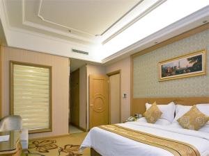 a hotel room with a large bed and a window at Vienna International Hotel Donglin Road in Nanjing