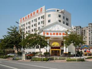 um grande edifício branco com uma loja em frente a uma rua em Vienna Hotel Foshan Ceramic City em Foshan