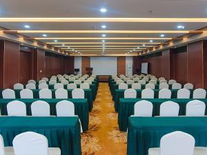 sala konferencyjna z zielonymi stołami i białymi krzesłami w obiekcie Vienna Hotel Shandong Qingdao Chengyang w mieście Xifu