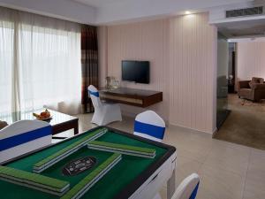 una sala de estar con mesa de billar en una habitación de hotel en Vienna Hotel Dongguan Houjie Avenue, en Dongguan