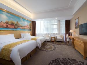 a hotel room with two beds and a television at Vienna Hotel Guangzhou Baiyun Airport in Guangzhou