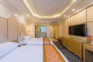 um quarto de hotel com duas camas e uma televisão de ecrã plano em Vienna International Hotel Qinghai Xining Tianjun Bridge em Xining