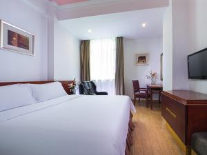 a hotel room with a large bed and a desk at Vienna 3 Best Hotel Foshan Nanhai Film Studio City in Nanhai