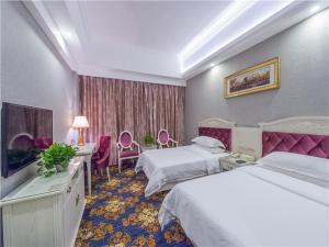 a hotel room with two beds and a television at Vienna Hotel Guilin ShiFu Branch in Lingui