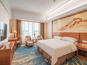 Vienna Hotel Zhengzhou Airport tesisinde bir odada yatak veya yataklar