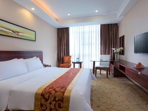 a hotel room with a large bed and a desk at Vienna Classic Hotel Guangzhou Yanling Road in Guangzhou