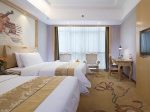 ein Hotelzimmer mit 2 Betten und einem Schreibtisch in der Unterkunft Vienna Hotel Guangxi Nanjing Nanhu Park in Nanning