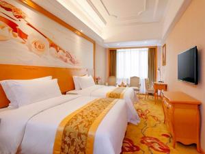 Cette chambre comprend 2 lits et une télévision à écran plat. dans l'établissement Vienna International Hotel Guangzhou Airport Xinshi, à Canton