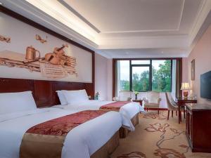 a hotel room with two beds and a large window at Vienna Hotel Shenzhen Longzhu in Shenzhen
