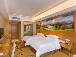 ein Hotelzimmer mit zwei Betten und einem Gemälde an der Wand in der Unterkunft Vienna Hotel Guangzhou Beijing Road in Guangzhou