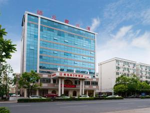 ein großes Gebäude mit einem Schild darüber in der Unterkunft Vienna 3 Best Hotel Meizhou Mei County People Square in Meizhou