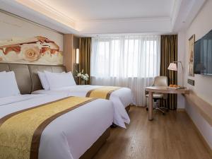 Habitación de hotel con 2 camas, escritorio y ventana en Vienna International Hotel (Changfeng Park Shop, Jinshajiang Road, Shanghai) en Shanghái