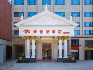 a building with a large white building with columns at Vienna Hotel Wuhan Panlong City in Wuhan