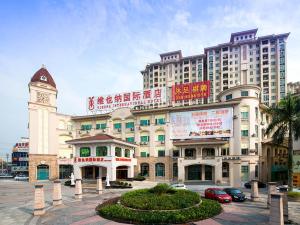 a large building with a clock tower in front of it at Vienna International Hotel Guangzhou Xintang Jean Fangzhicheng in Zengcheng
