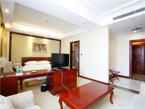 ein Zimmer mit einem Bett und einem Schreibtisch mit einem Fernseher in der Unterkunft Vienna Hotel Suzhou Luokou Furniture Store in Suzhou + 6 Fotos